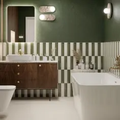 Elegancka łazienka z wanną, toaletą i drewnianą szafką. Ściany zdobią zielono-białe płytki, a blat pod umywalką wykonano z materiału przypominającego **duroplast**.