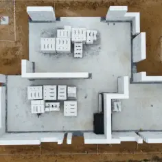 Budowa domu z bloczków betonowych. Fundamenty i pierwsze warstwy ścian gotowe. Rozpoczęcie prac budowlanych to dobry moment na sprawdzenie system 3e cena m2.