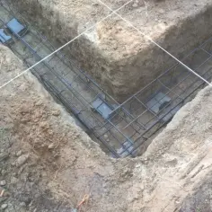 Gotowe zbrojenie fundamentu w wykopie. Stalowe pręty tworzą siatkę, która wzmocni beton.